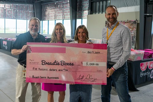 four people holding a large donation check for Breastie Boxes